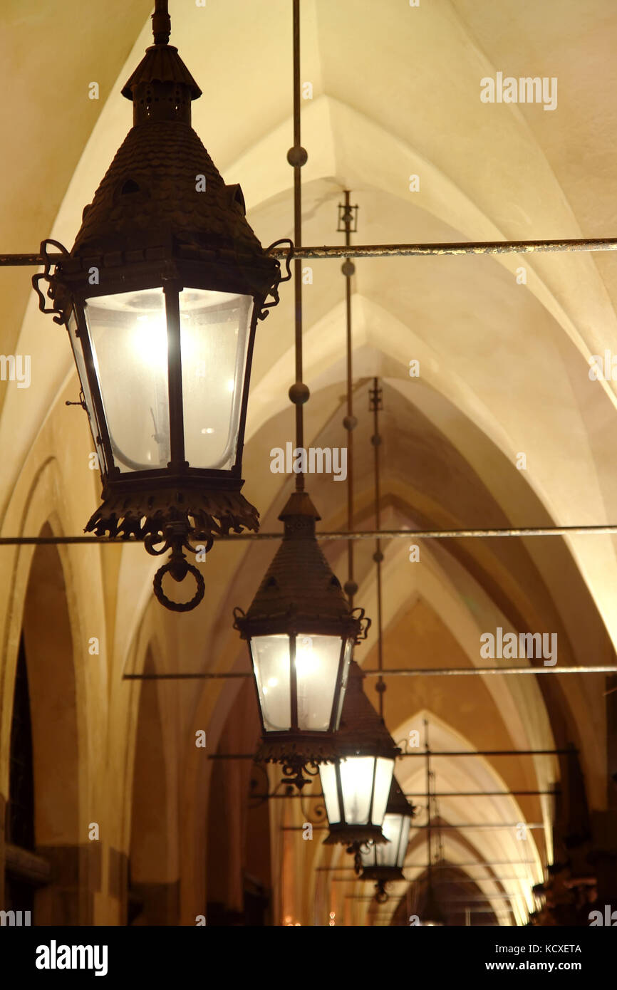 Closeup of old stylish lanterns illuminating gothic arcade Stock Photo