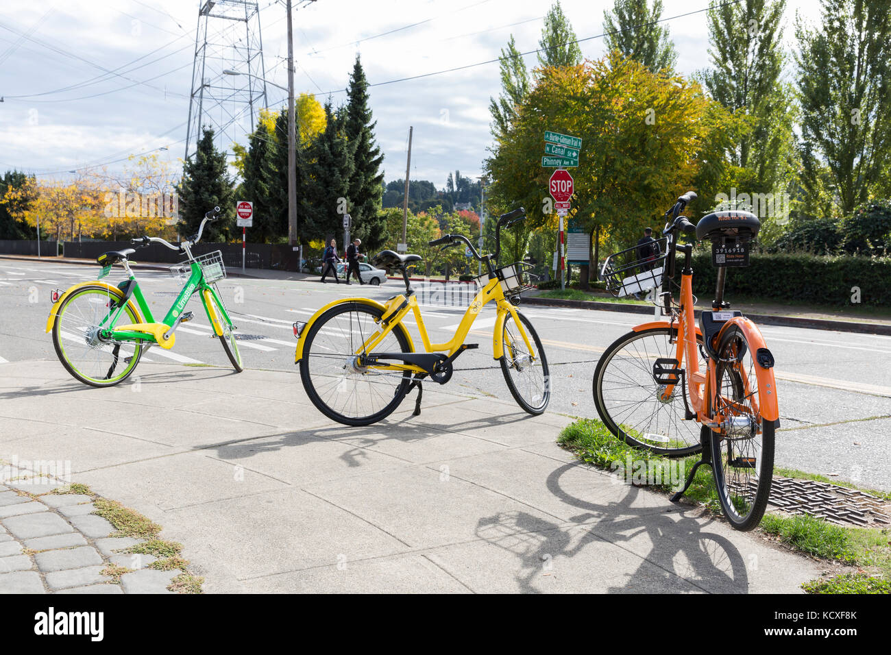 Seattle, Washington: A variety of cycle-share bikes parked at in the Fremont neighborhood. LimeBike (green), Ofo bike (yellow) and Spin bike (orange)  Stock Photo