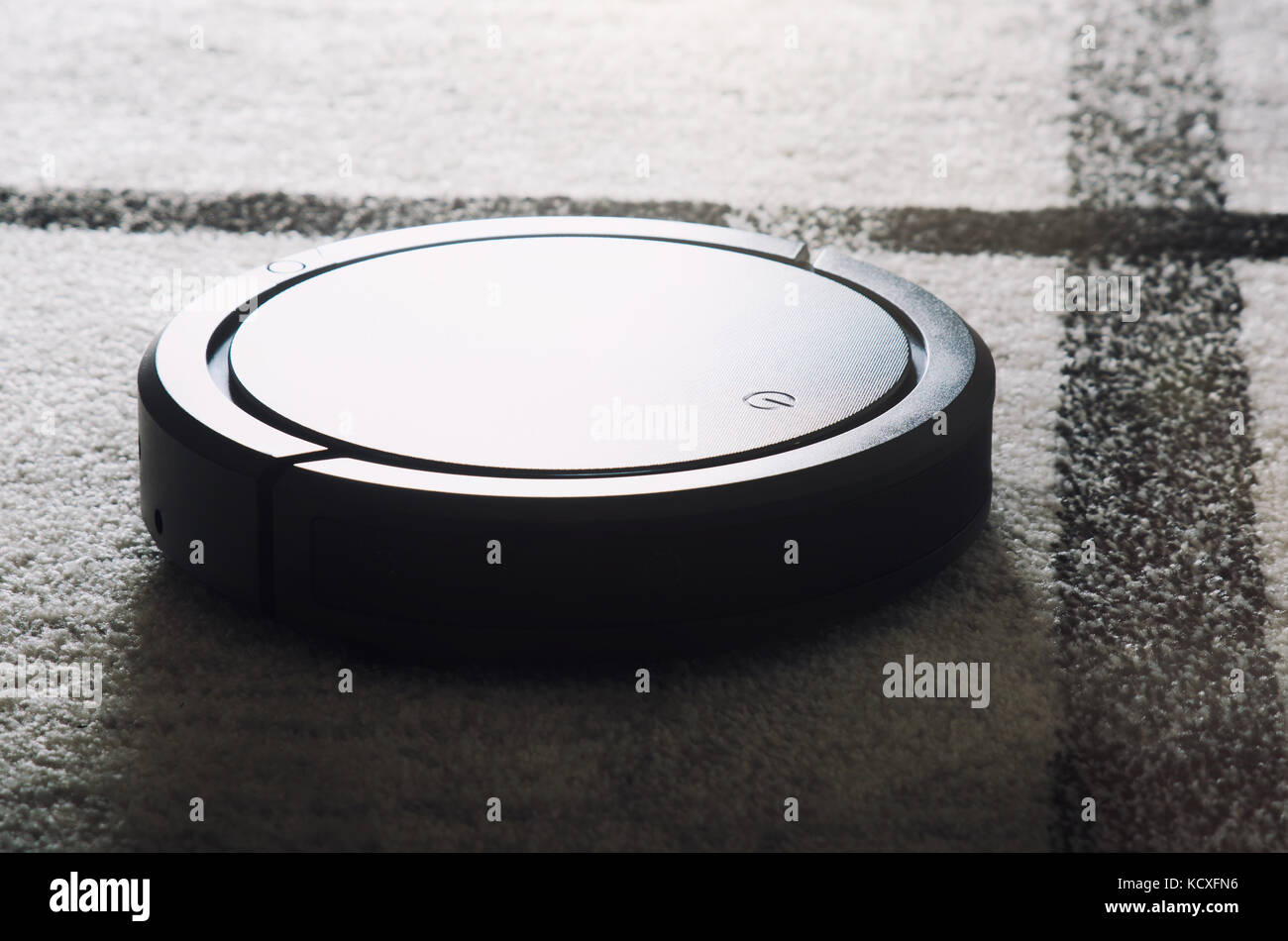 Robotic vacuum cleaner working on carpet. Smart cleaning technology