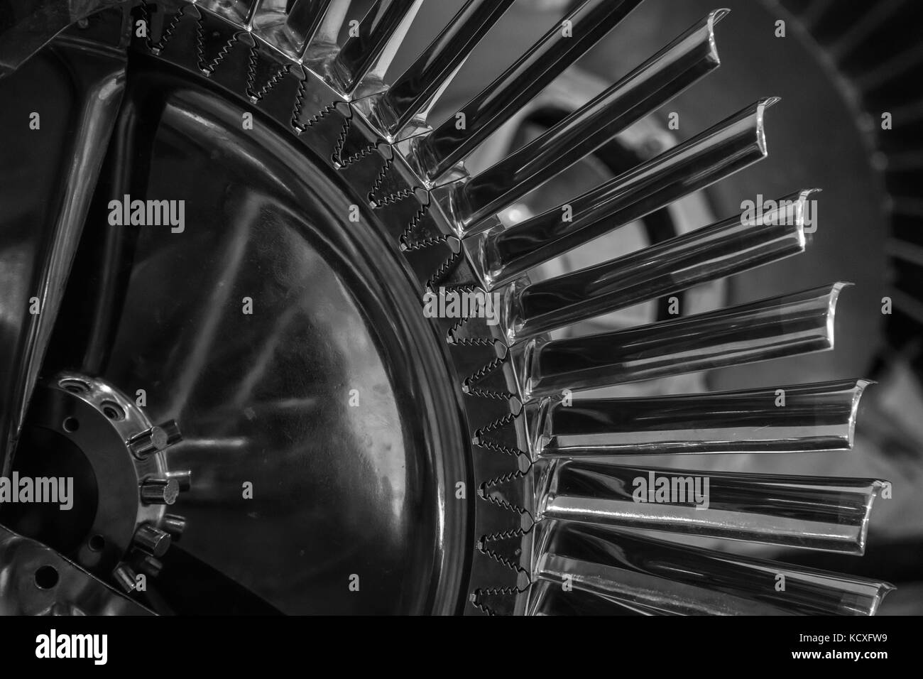 Turbine fan blades viewed from a cutaway of a small jet engine exposing the curved fan blades that duct air for power Stock Photo