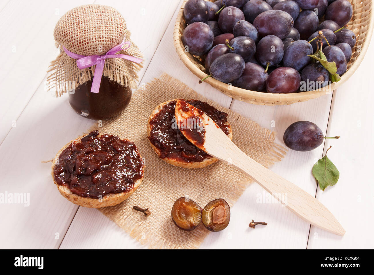Wooden knife, sandwiches with plum marmalade or jam on jute burlap, concept of preparation delicious breakfast Stock Photo