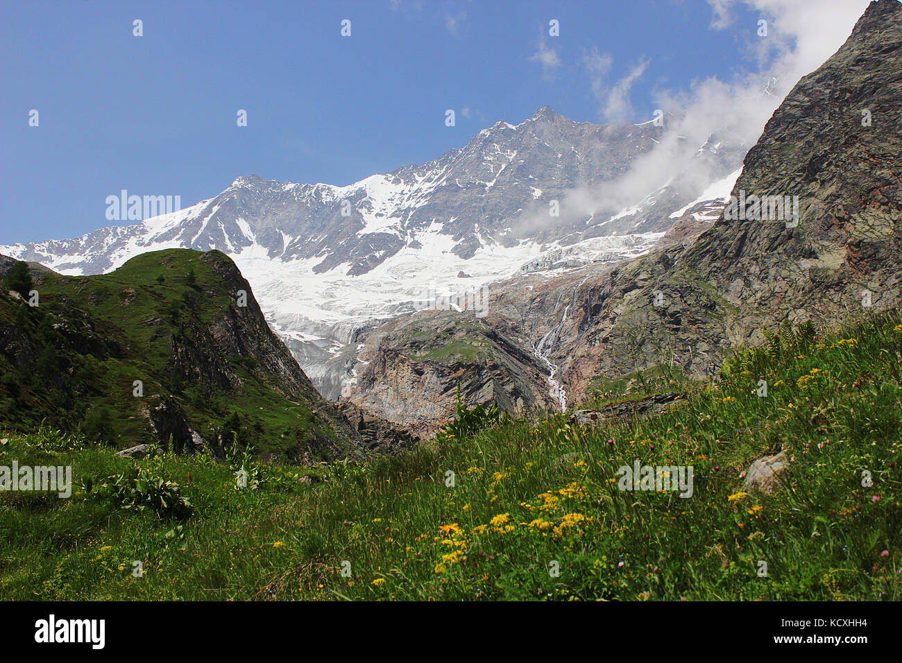 Dom and the surrounding mountains of Saas Fee and the Alpine meadows in Valais, Switzerland. Stock Photo