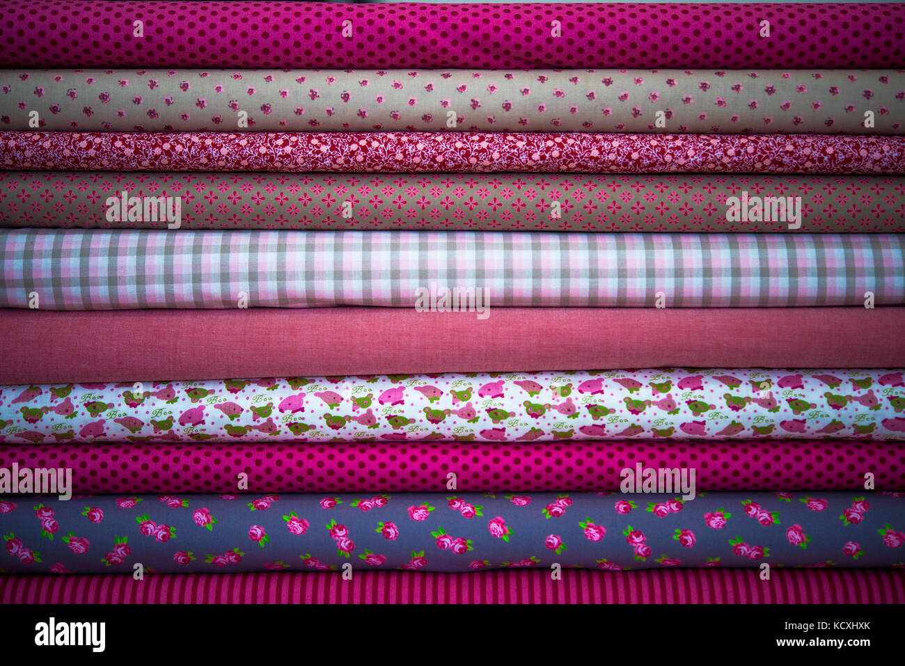 Stack of fabric red pink cloth rolls Stock Photo - Alamy