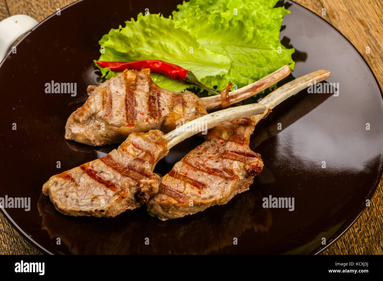 Grilled lamb with tomato sauce served salad leaves Stock Photo Alamy