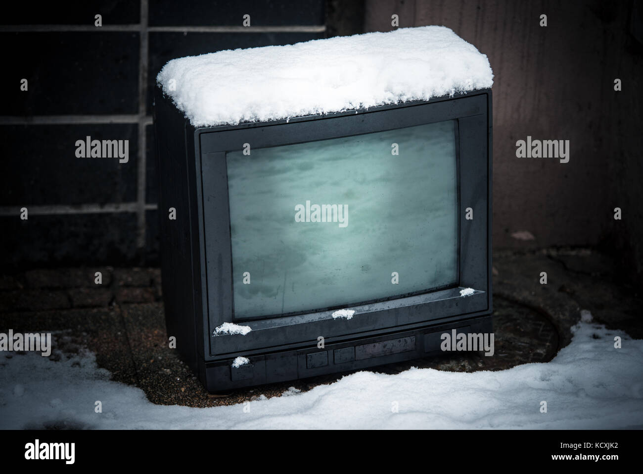 Old tv on street in winter with snow Stock Photo