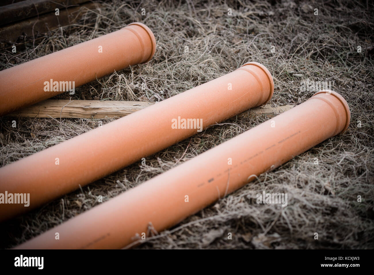 Three orange pipes on the floor Stock Photo Alamy