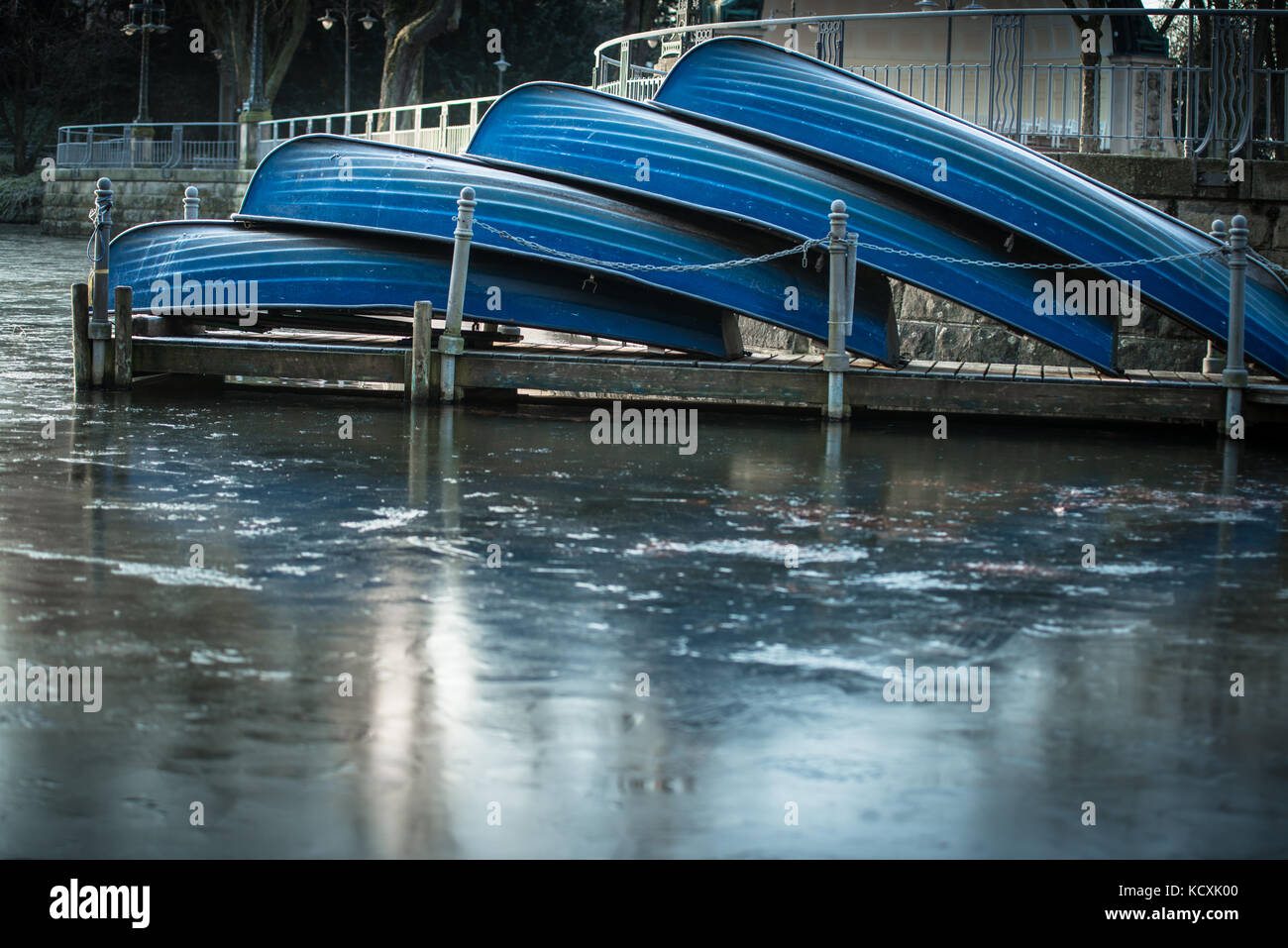 Four rowing boats at a frozen lake lying on the pier Stock Photo - Alamy
