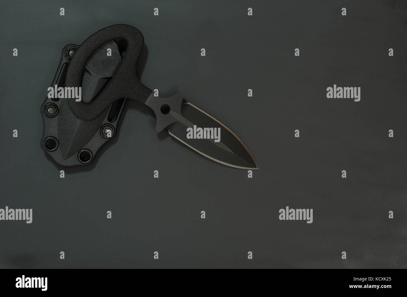 Military black knife on a black background. Diagonal composition. Flat lay. Stock Photo