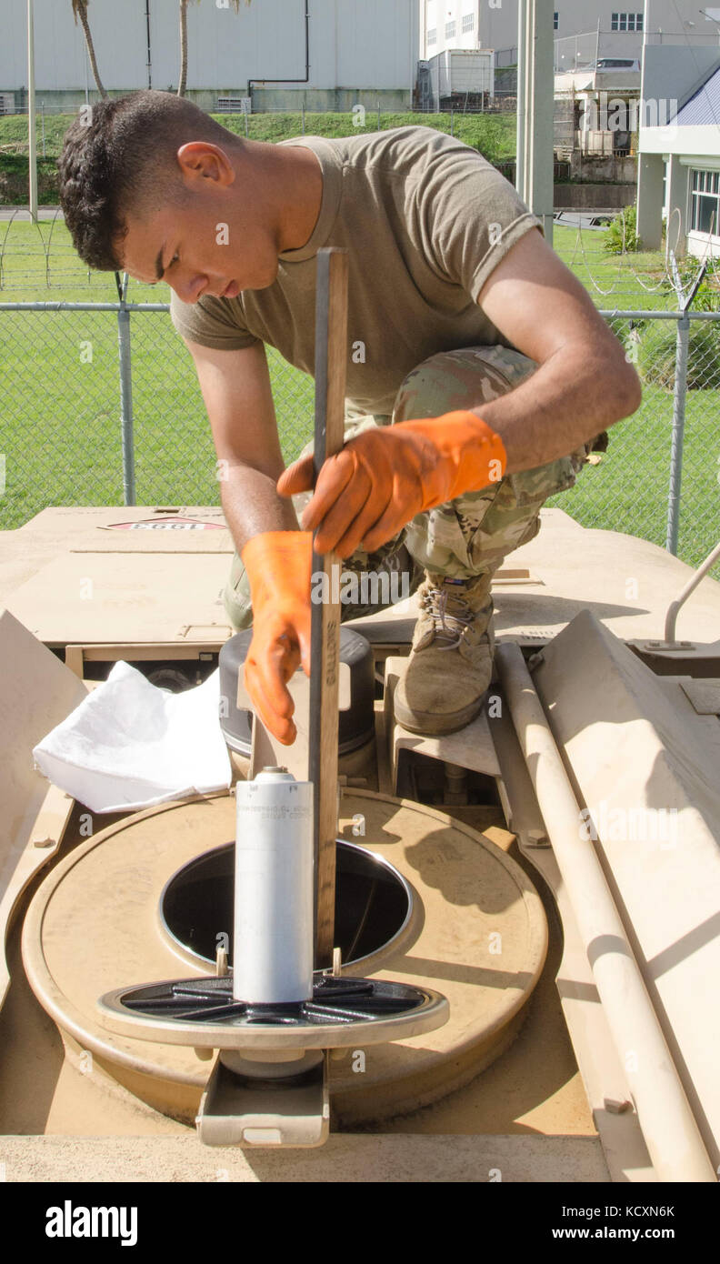 U.S. Army Reserve Pvt. Caleb Gonzalez, a petroleum supply specialist, assigned to the 941st Quartermaster Company, 346th Transportation Battalion, 166th Regional Support Group, 1st Mission Support Command, out of Salinas, Puerto Rico, gauges the fuel tank prior to a fuel delivery mission, at Fort Buchanan, Puerto Rico, Oct. 5, 2017. Gonzalez is part of America's Army Reserve immediately responding to natural and man-made disasters at the request of local authorities. (U.S. Army Reserve photo by Sgt. Carlos J. Garcia) Stock Photo