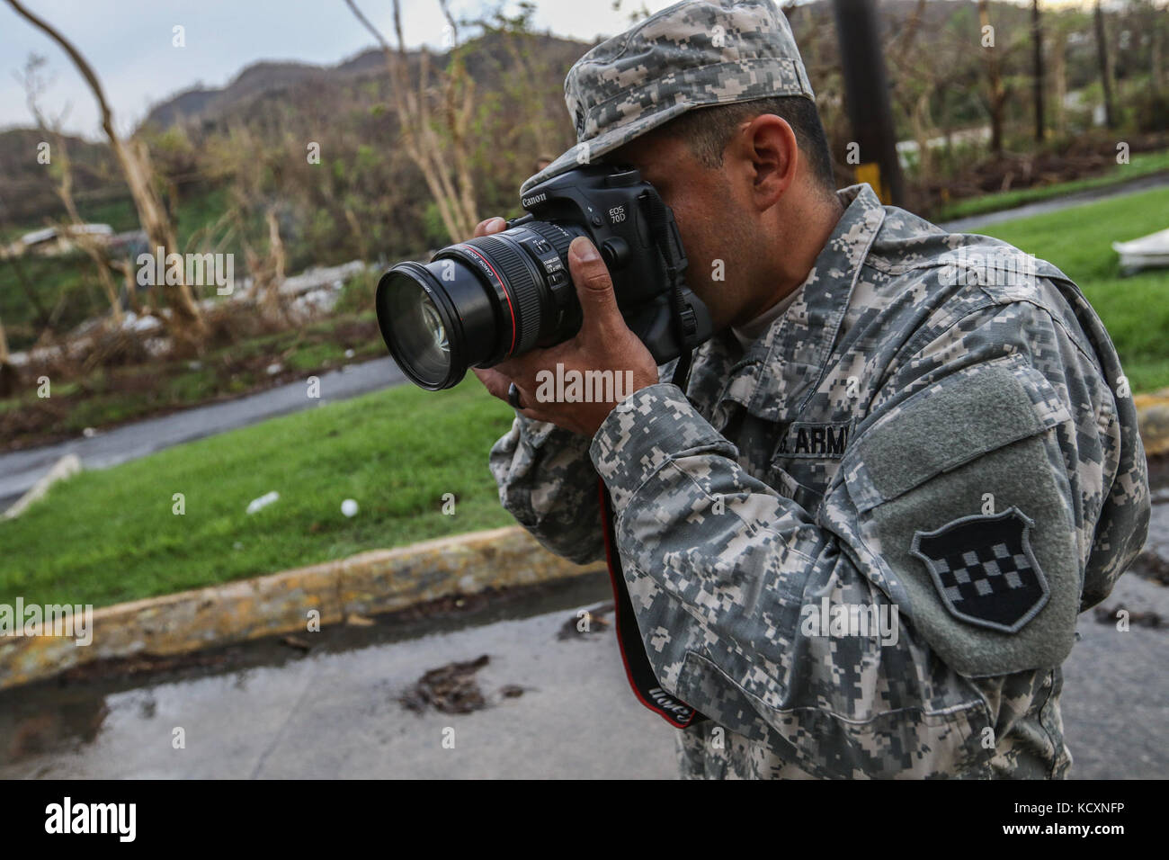 U.S. Army Reserve soldier, Sgt. Edgar Valdez, 220th Public Affairs Detachment, takes photos during a food delivery mission, which is part of Hurricane Maria relief efforts, outside of San Juan, Puerto Rico on Oct. 6, 2017. Valdez is part of a public affairs team that has spent the past several days working with Army Reserve soldiers, under the guidance and request of civil authorities, who are providing much needed supplies and resources to all of Puerto Rico. America’s Army Reserve can provide logistical, medical, and engineering support within hours of a disaster. Valdez is a public affairs  Stock Photo