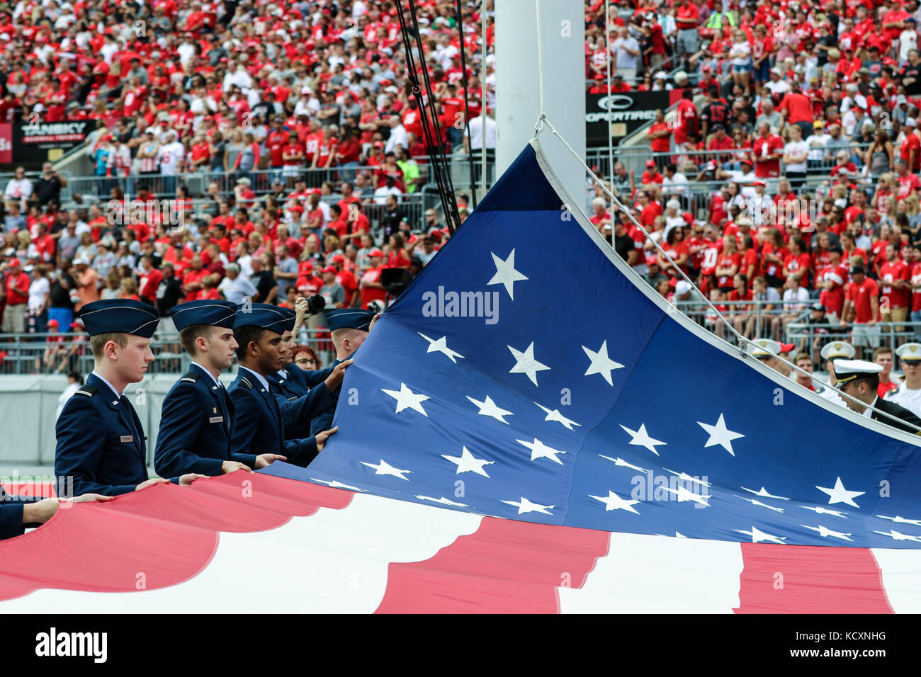 Members of The Ohio State University Reserve Officers’ Training Corps raise the U.S. flag before kickoff of the OSU-Army game Sept. 16, 2017, at Ohio Stadium in Columbus, Ohio. It was the first time the teams have played against each other, although both have fielded football teams for more than 100 years. (Ohio National Guard photo by Staff Sgt. Michael Carden) Stock Photo