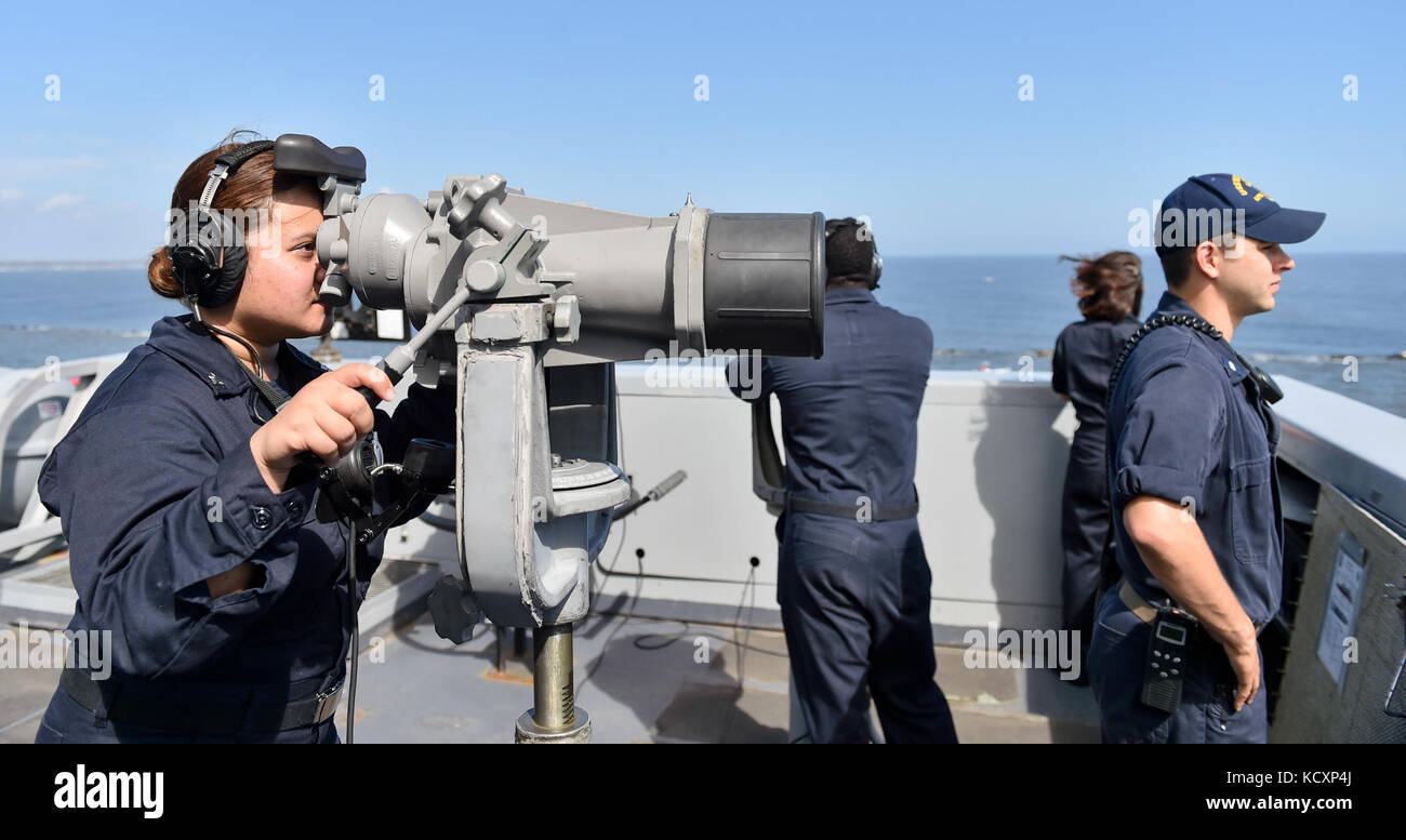 171007-N-PC620-0045  MAYPORT, Fla. (Oct. 7, 2017) Culinary Specialist 2nd Class Justinne Ivanitsky, a native of the Philippines, stands port lookout during sea-and-anchor evolutions aboard the amphibious transport dock ship USS New York (LPD 21). New York departed Naval Station Mayport, Florida, to support the Gulf coast region in the event assistance is needed in the wake of Hurricane Nate. (U.S. Navy photo by Mass Communication Specialist Seaman Michael Lehman/Released) Stock Photo