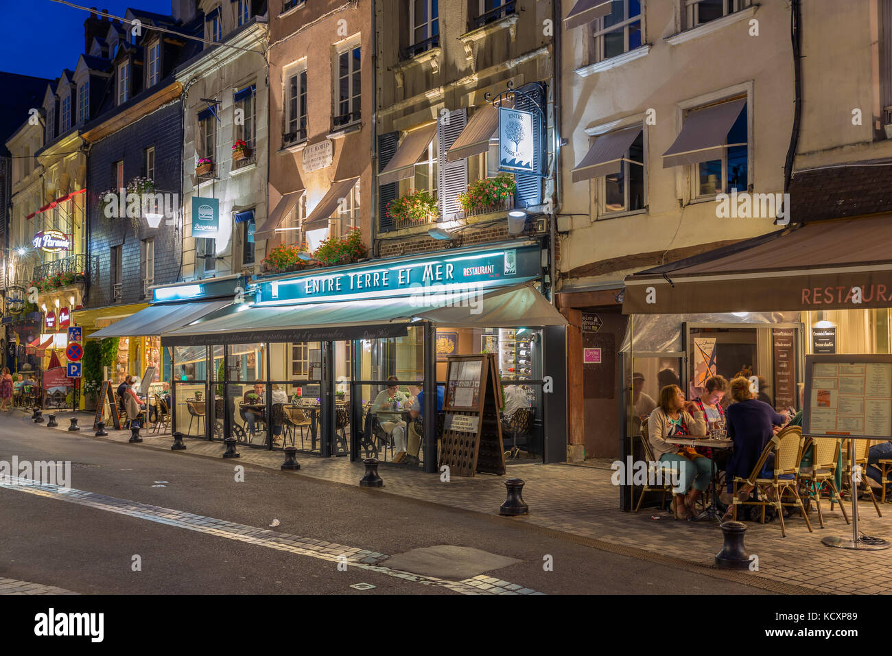 Historic city Honfleur with people at terraces in the evening Stock Photo