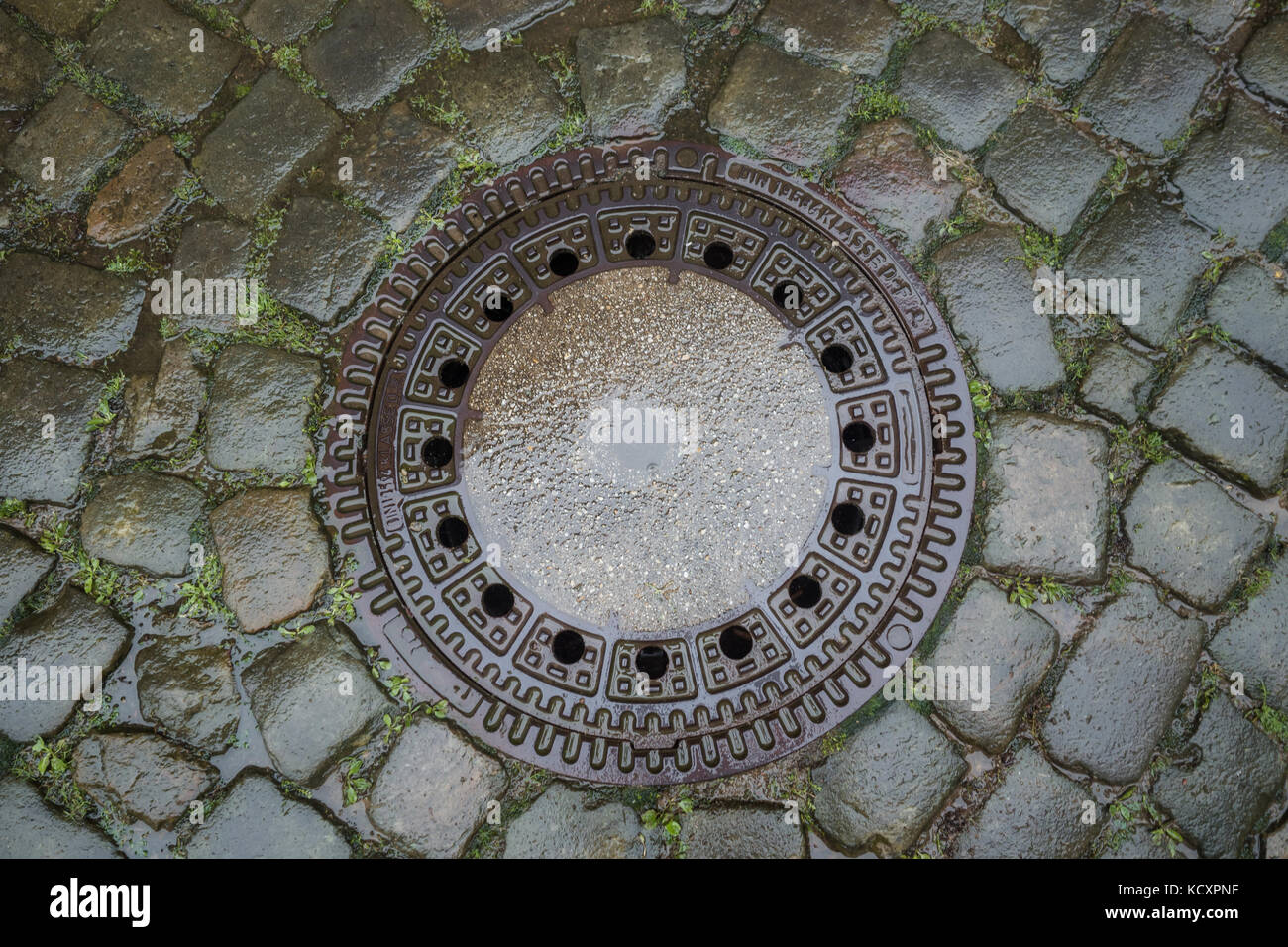 Drain cover in the middle of a road Stock Photo Alamy