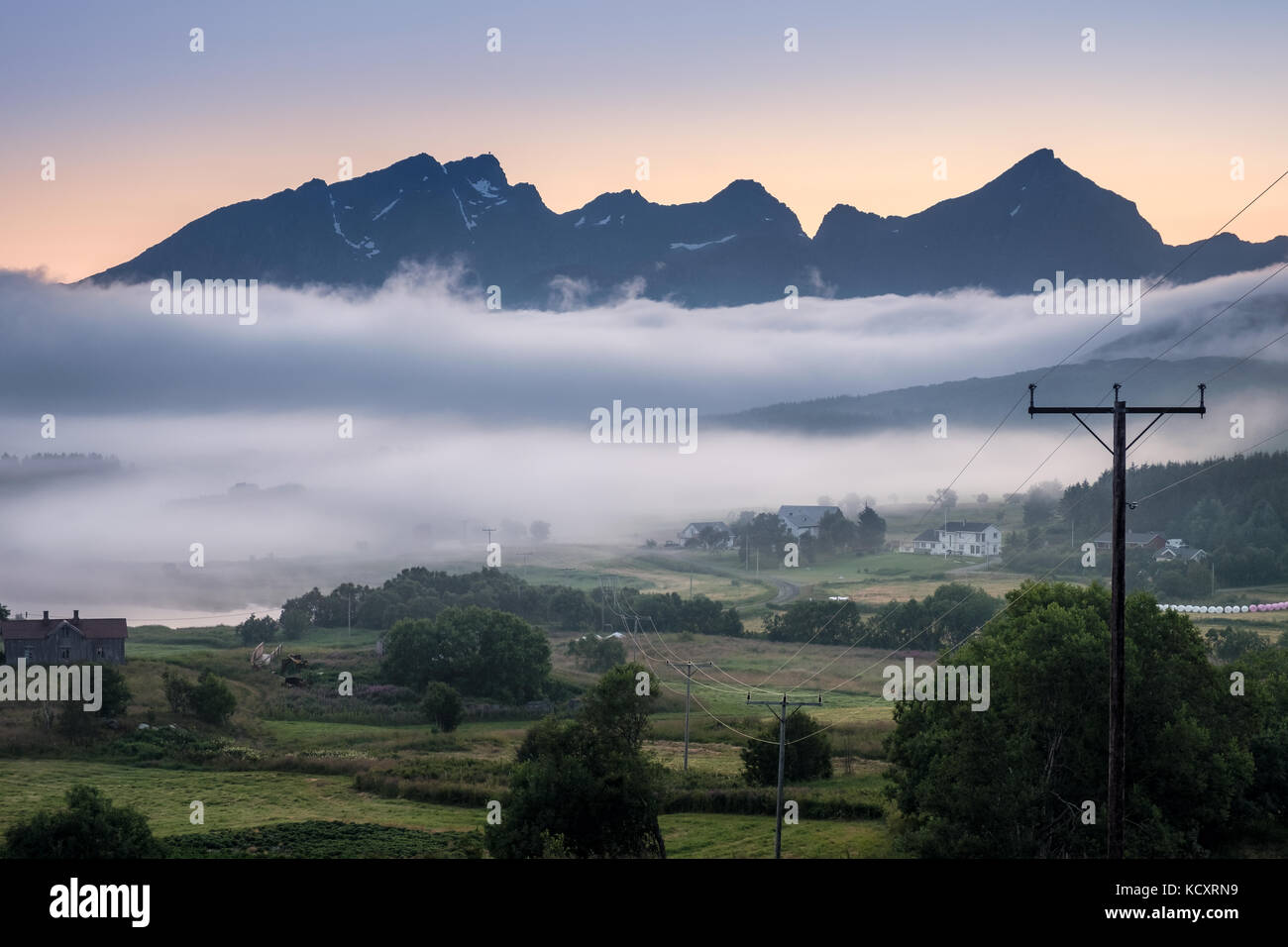 Scenic view from valley with mountain and hard fog at summer evening in Lofoten, Norway Stock Photo