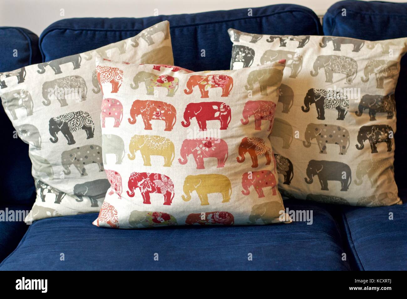 Elephant patterned cushions on blue sofa Stock Photo Alamy
