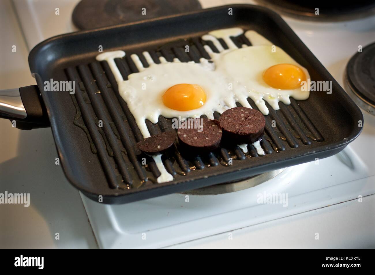 Eggs and black pudding on the hob Stock Photo
