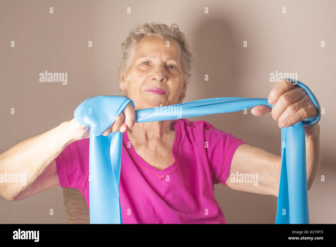 Rehabilitation exercises for older women with elastic band Stock Photo
