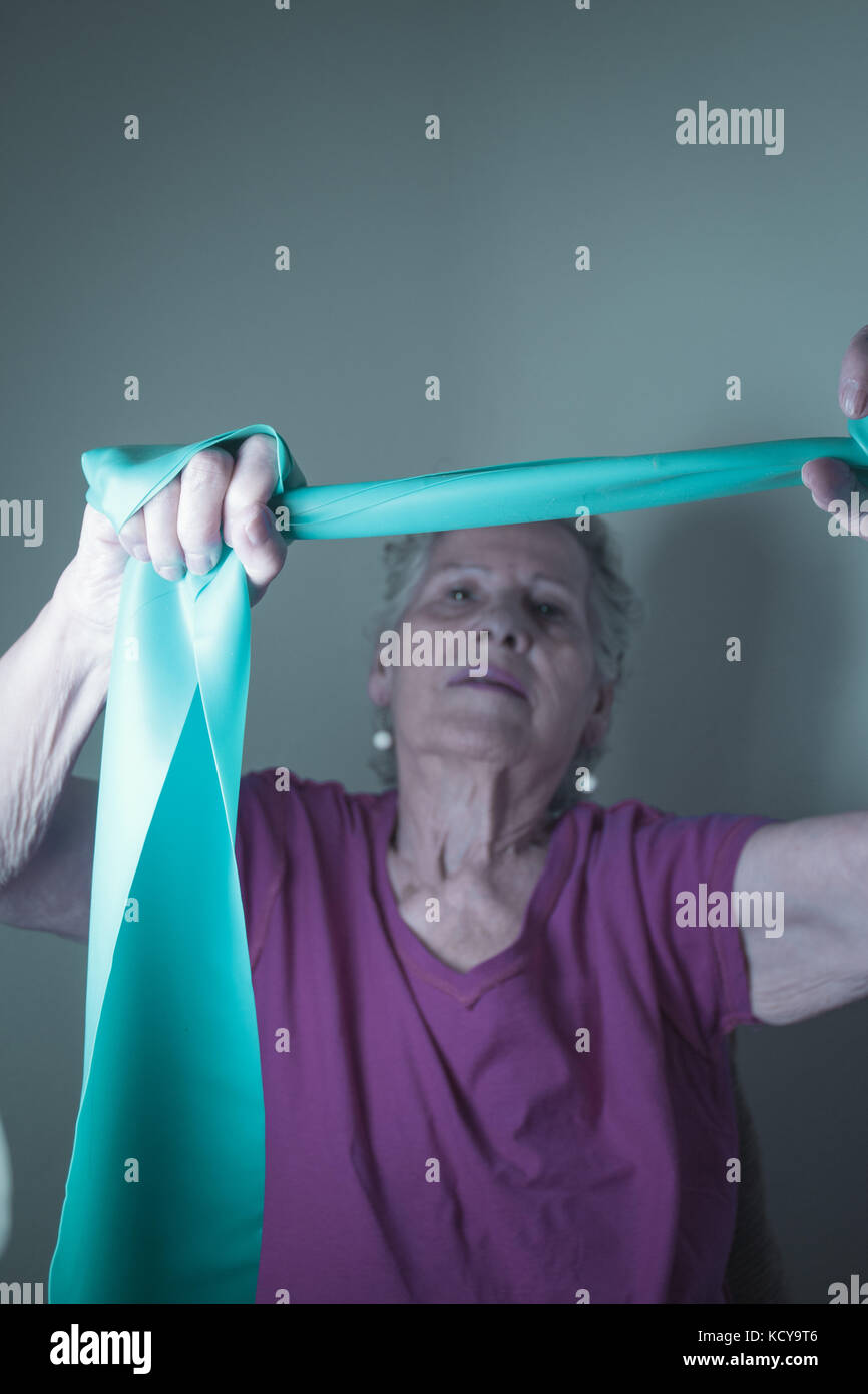 Rehabilitation exercises for older women with elastic band Stock Photo