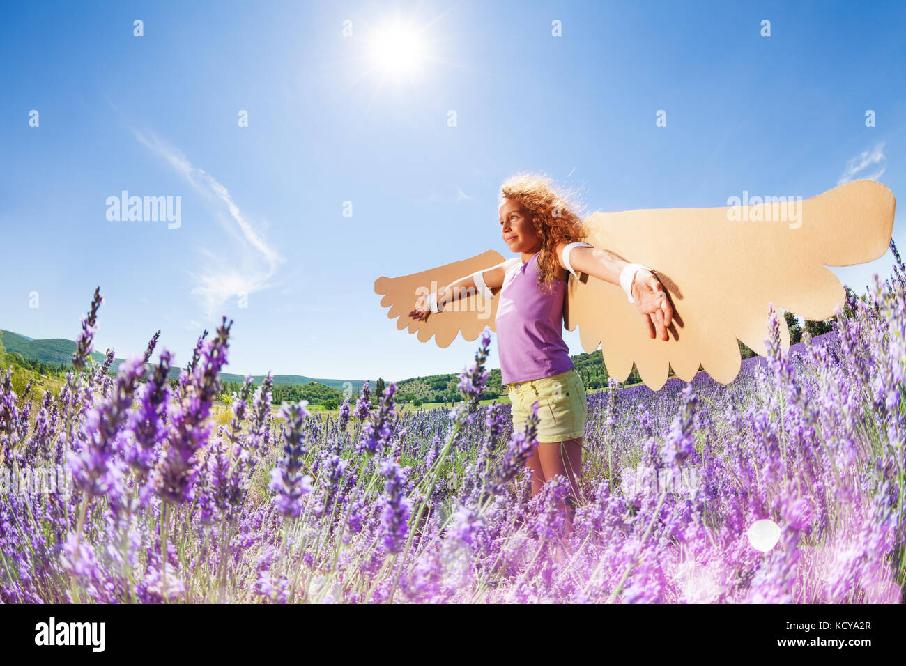 Side view portrait of happy preteen girl wearing homemade wings ...