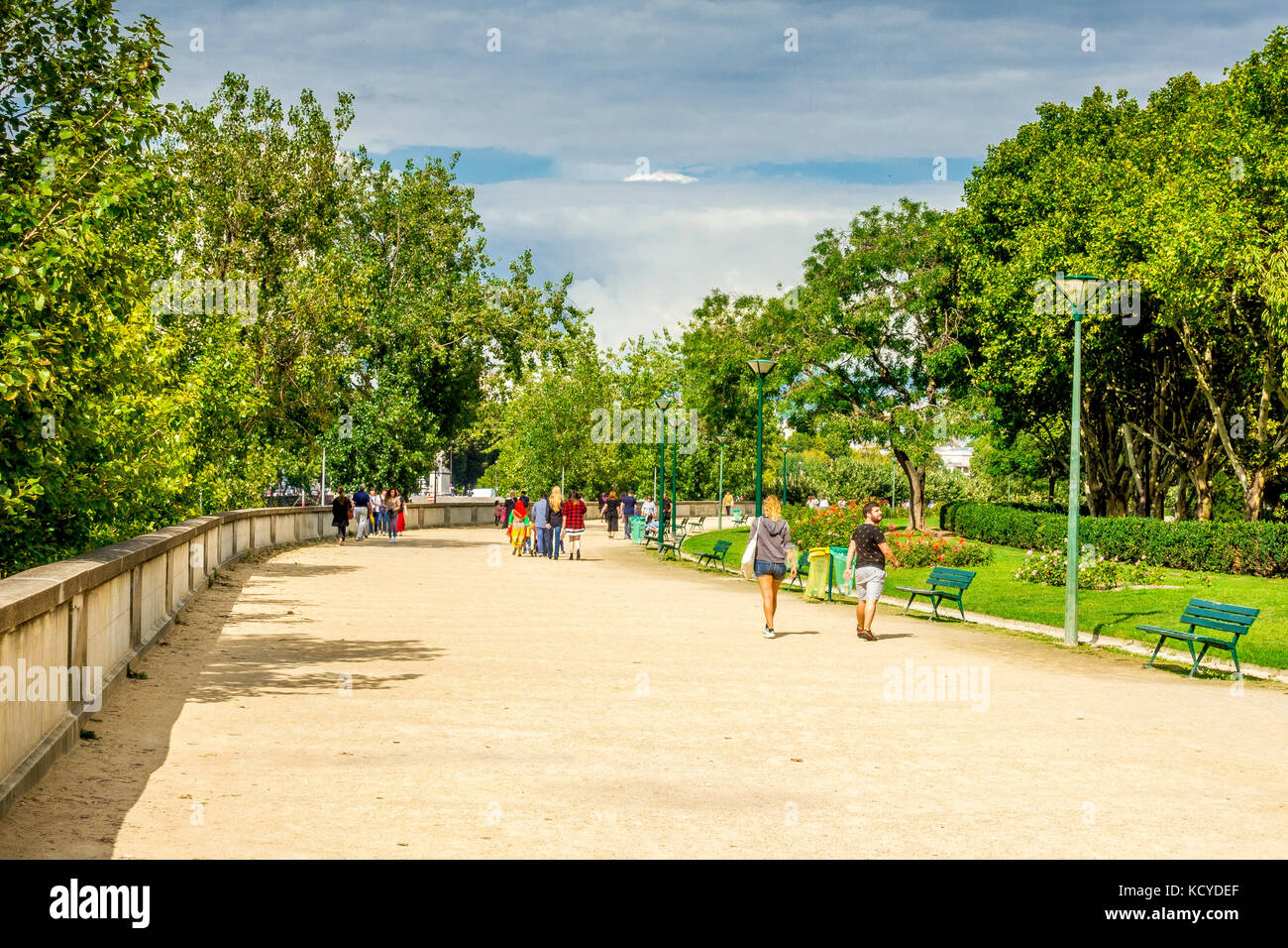Tourists and locals stroll by the Seine River on a sunny day in Paris, France Stock Photo