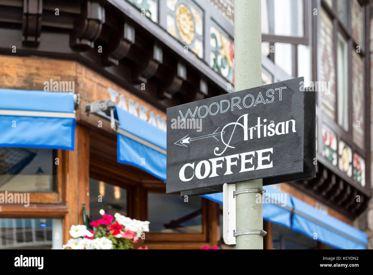 Artisan Coffee sign on a lamppost on the corner of Fairfax Place and Smith Street, Dartmouth Devon UK. Historic building with jettied upper floor Stock Photo