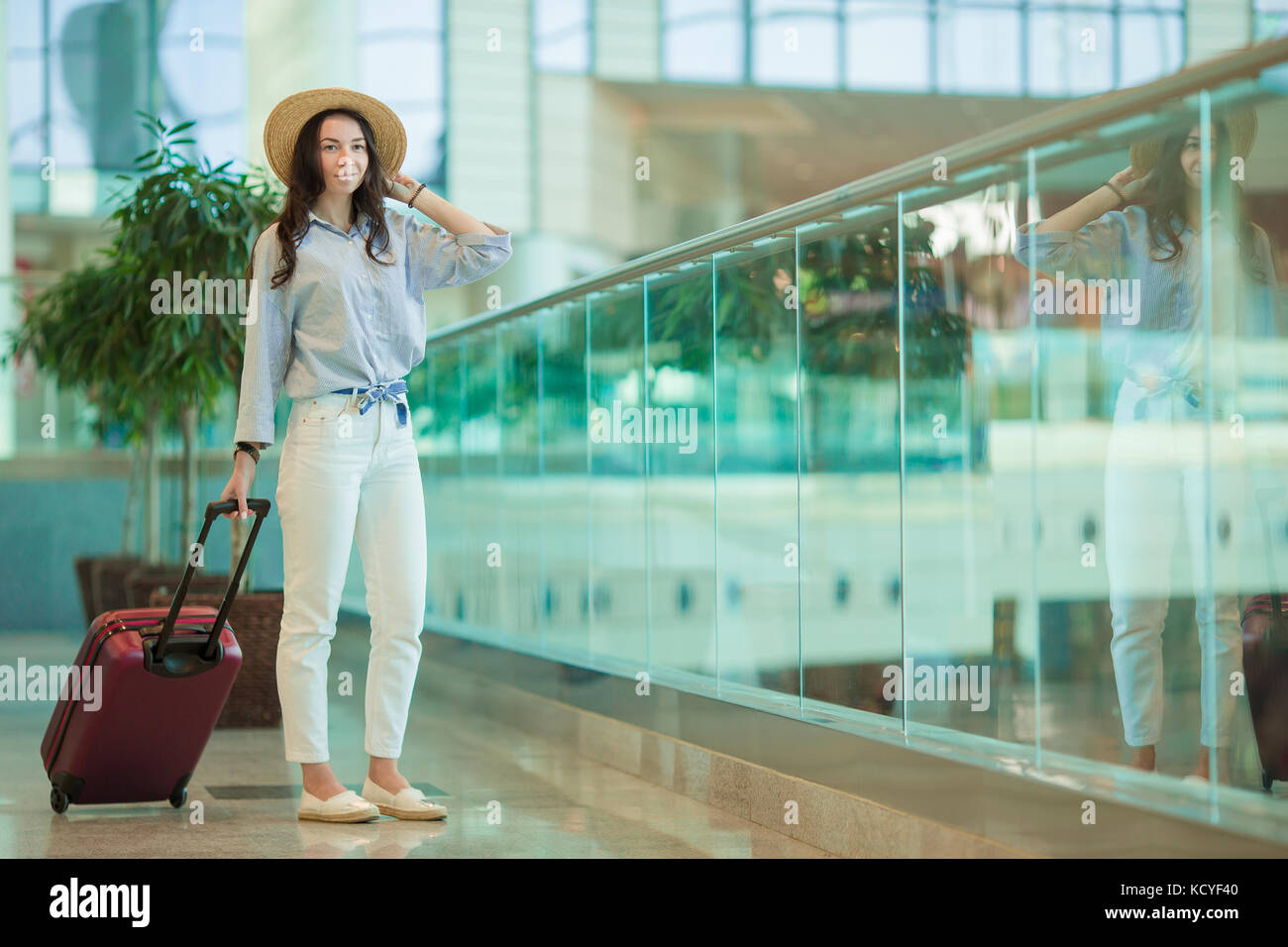 Young woman in international airport walking with her luggage Stock ...