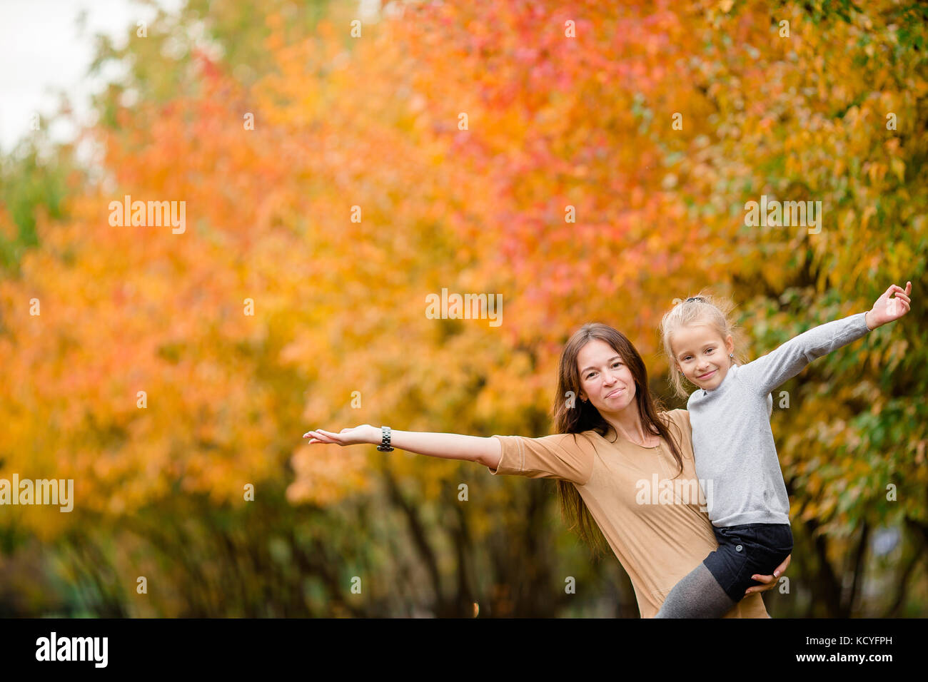 Young mother with cute little girl in autumn park on sunny day Stock ...