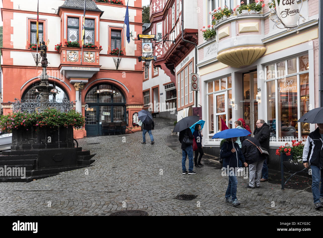 A wet, rainy day at the town of Bernkastel-Kues, in the Mosel Valley, Germany. The tourists have umbrellas to protect from the rain. Stock Photo