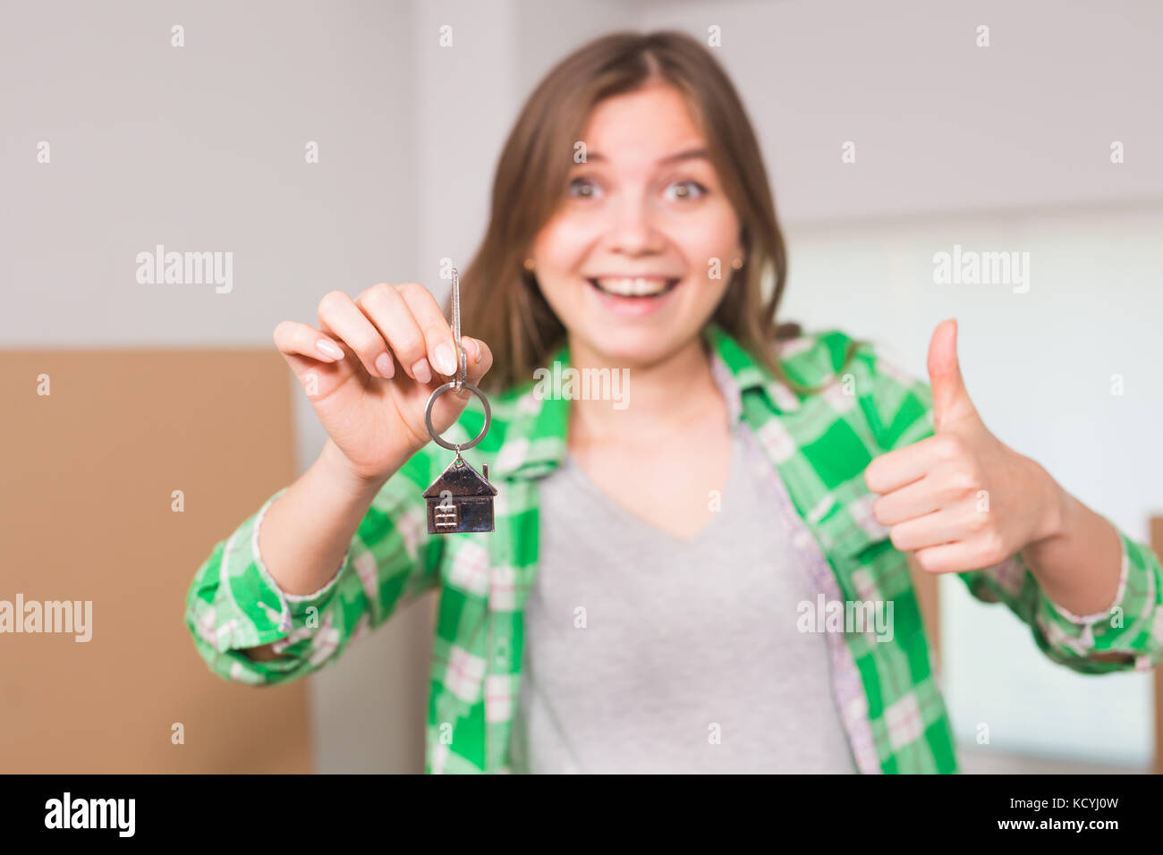 Happy apartment owner or renter showing keys and making thumbs up ...