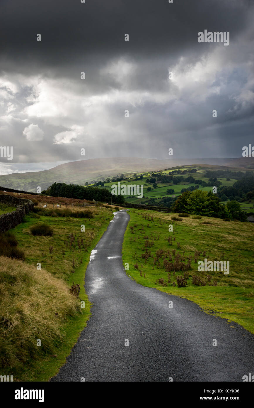 Stormy rain clouds above a country lane in Swaledale, North Yorkshire, England. Stock Photo
