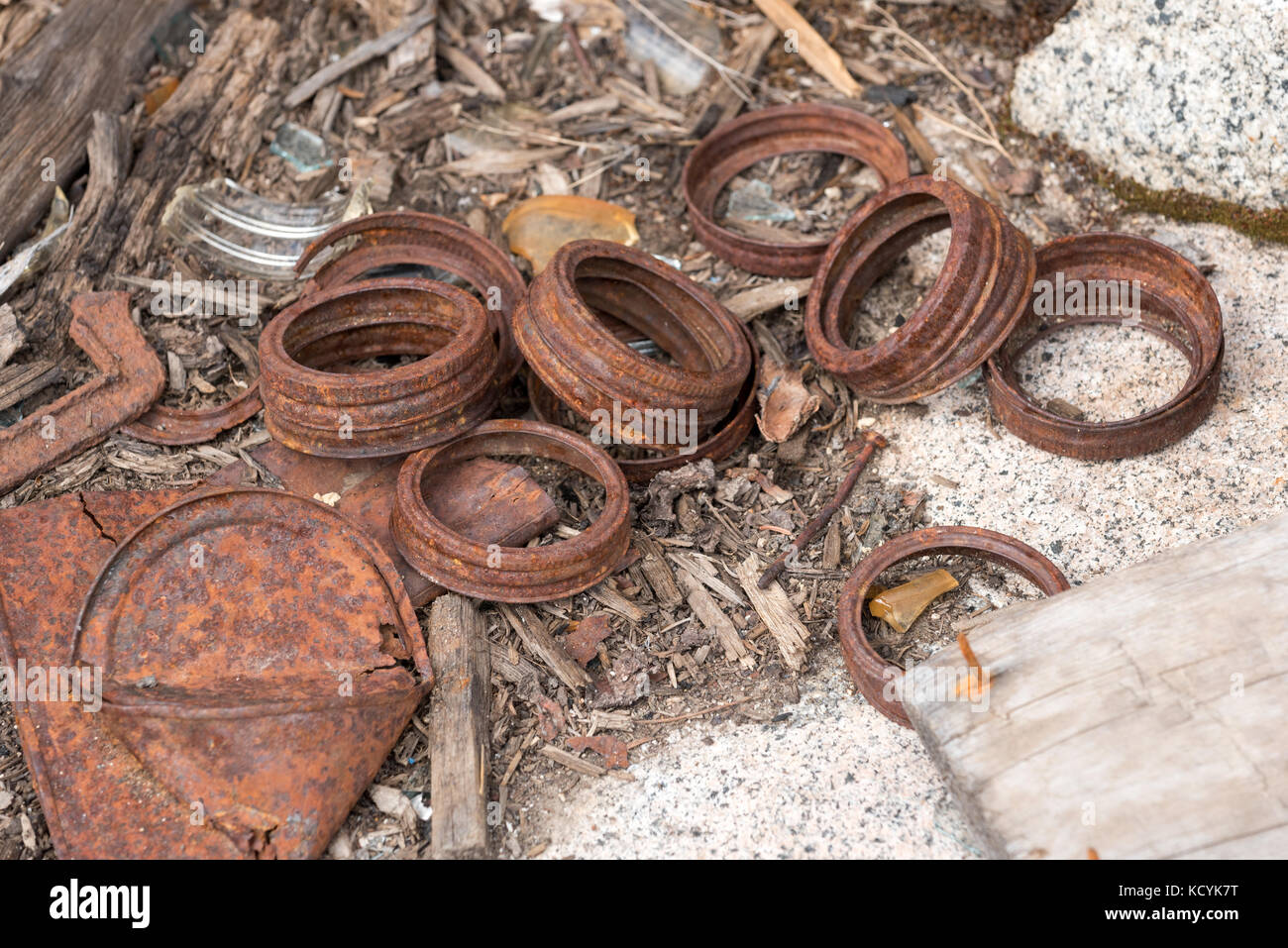 Rusted canning jar lids, nails and broken glass in an old mining camp in Oregon's Wallowa