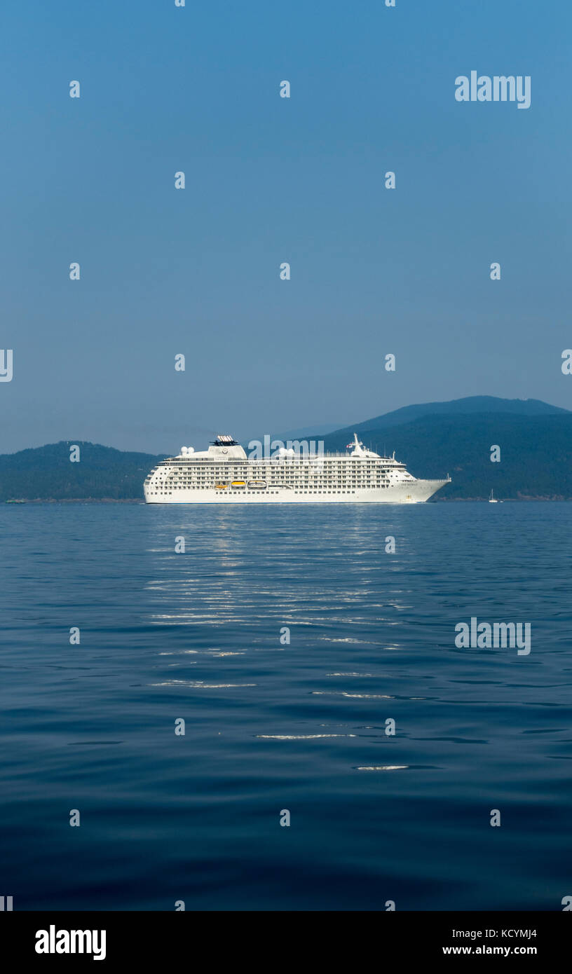 Luxurious and exclusive residential cruise ship The World, owned by a small number of of super rich clientele enters Vancouver harbour Stock Photo