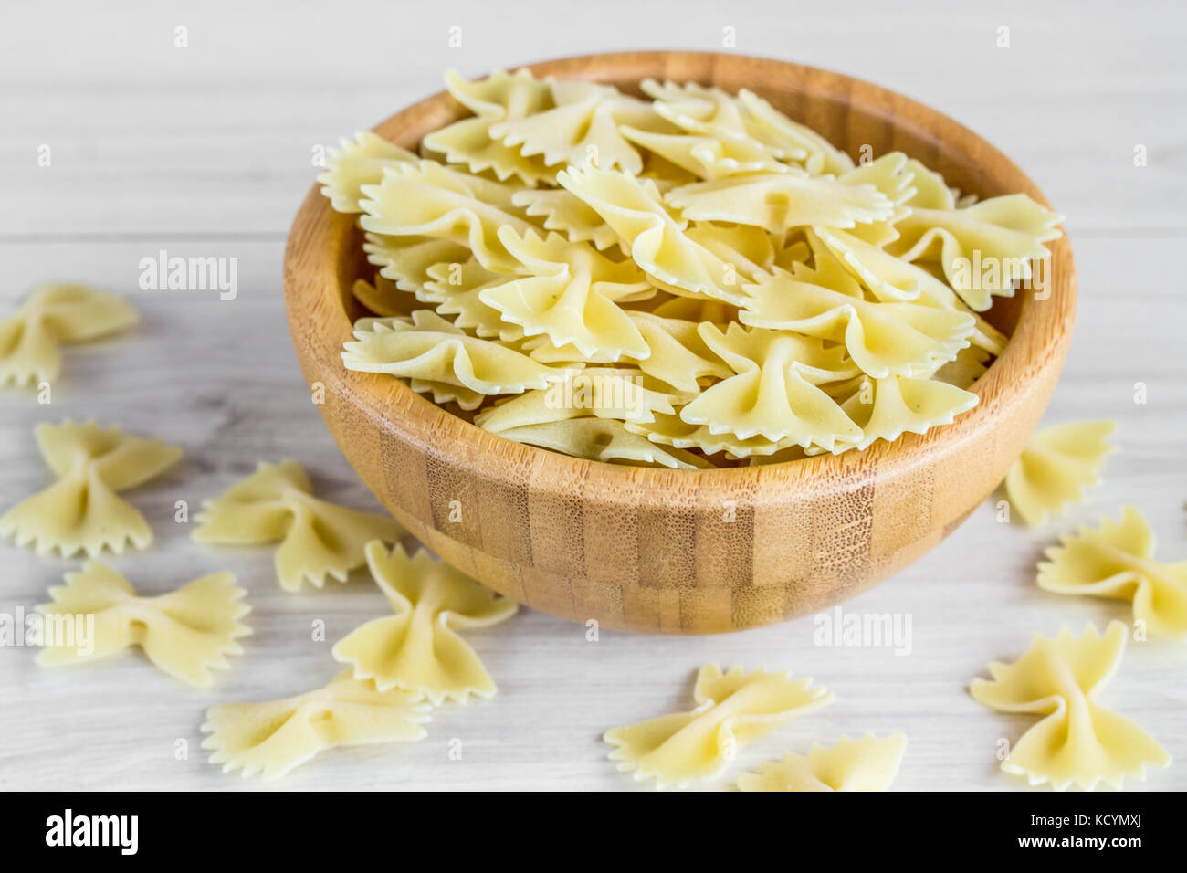 Dried italian bowtie pasta or farfalle on a wooden table. Stock Photo
