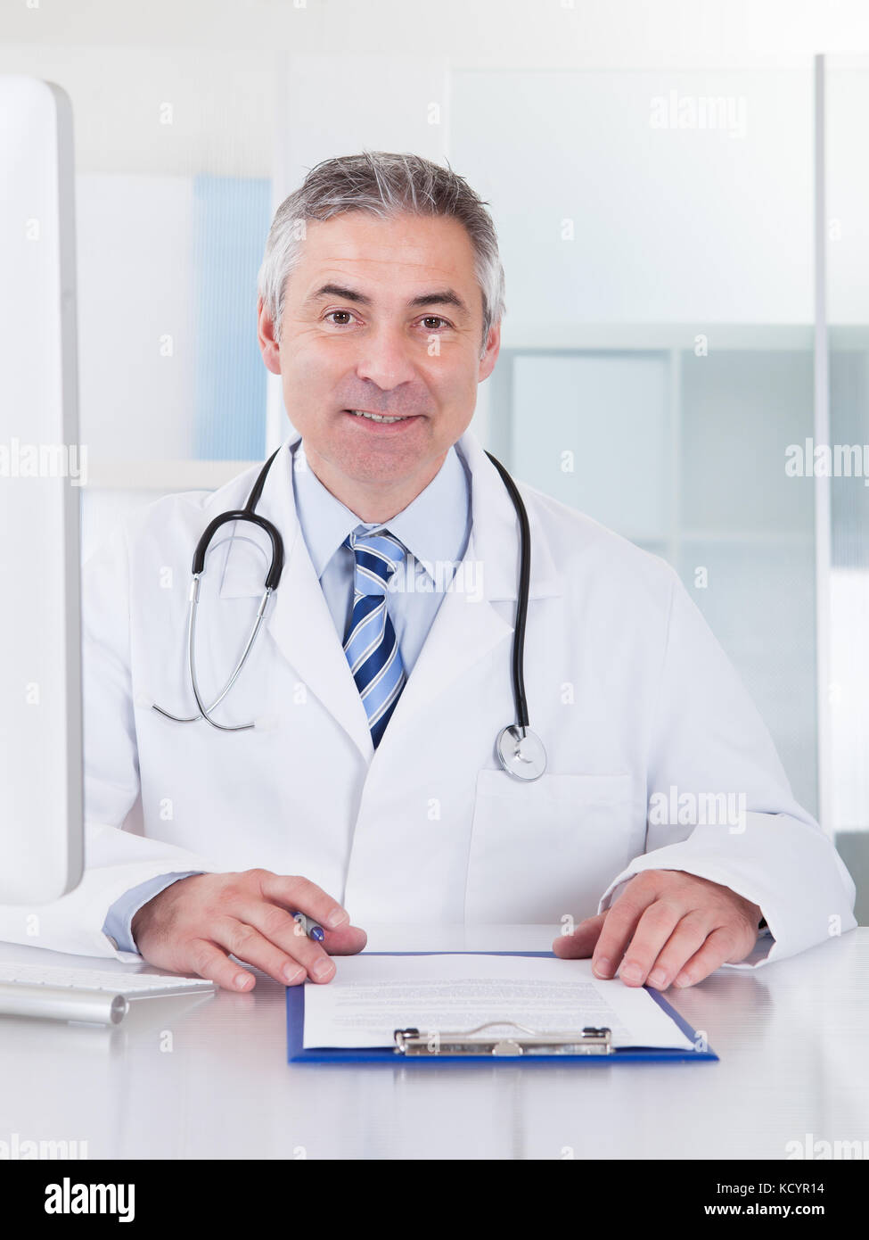 Portrait Of Happy Mature Male Doctor Working At Desk Stock Photo - Alamy
