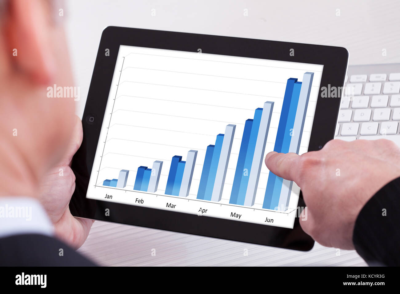 Businessman Holding Digital Tablet Showing Growth Graph Stock Photo - Alamy