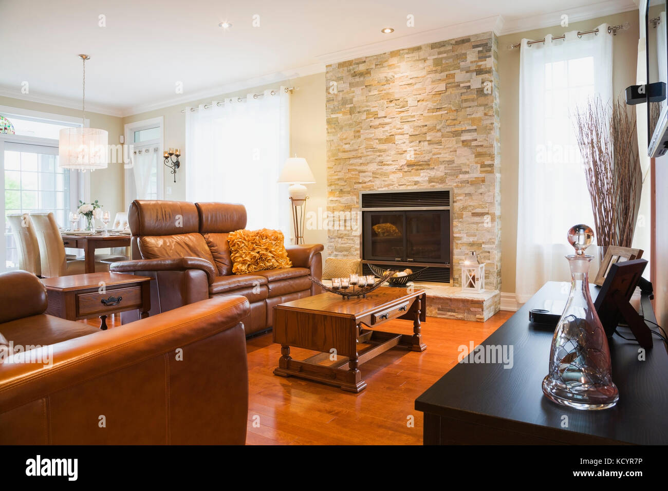 Brown Leather Sofas With Wooden Coffee Table And Wood Burning