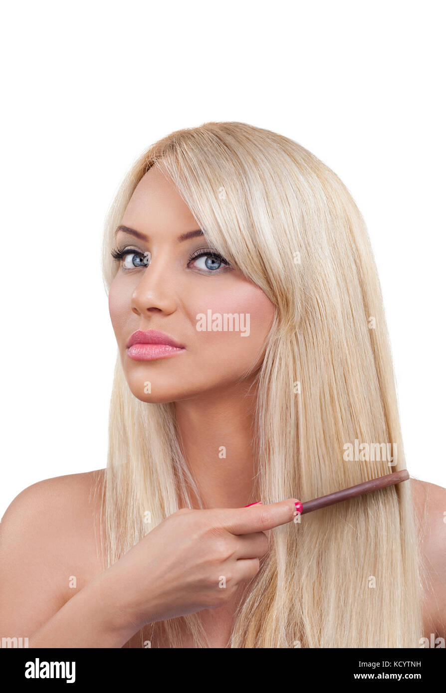 Young blond woman combing her hair Stock Photo