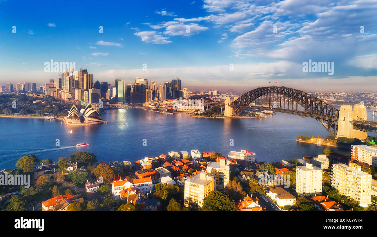 Major Sydney city landmarks around blue waters of Harbour surrounded by lower north shore suburbs and CBD circular quay at soft morning sun light unde Stock Photo