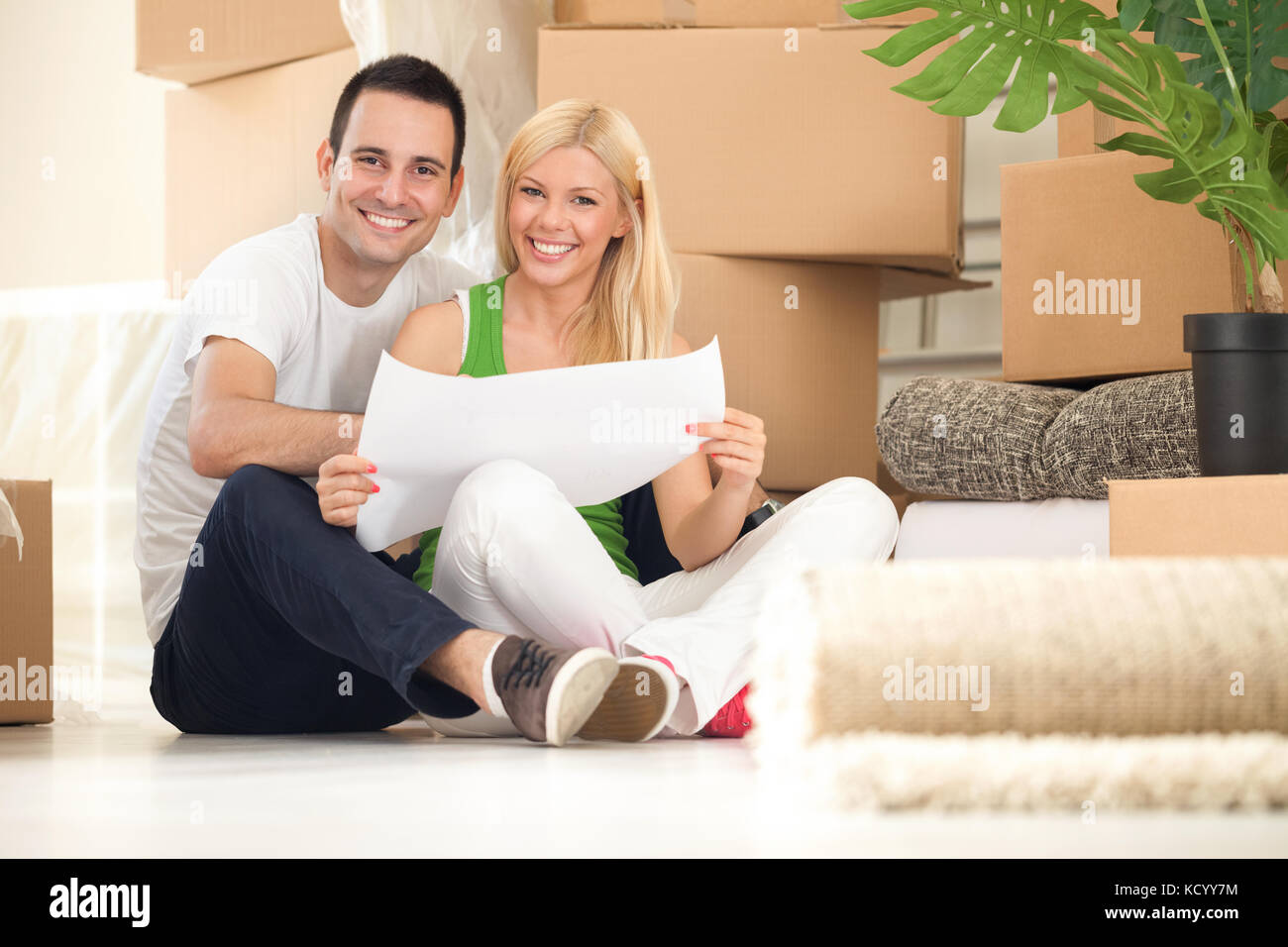 Young happy couple moving into their new home with plan Stock Photo - Alamy
