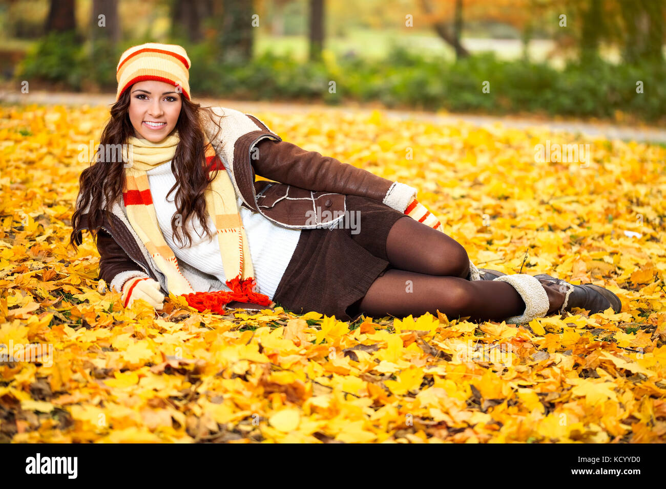 Attractive young woman lying in autumn leaves in park Stock Photo - Alamy