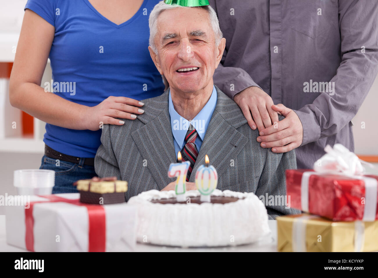 Happy senior man celebrating his 70th birthday with family Stock Photo