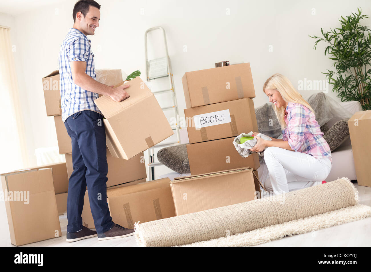 A young couple unpack moving boxes Stock Photo Alamy