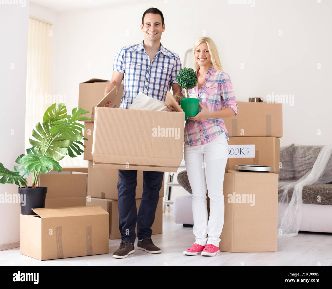 Cheerful young couple moving in their new home Stock Photo - Alamy
