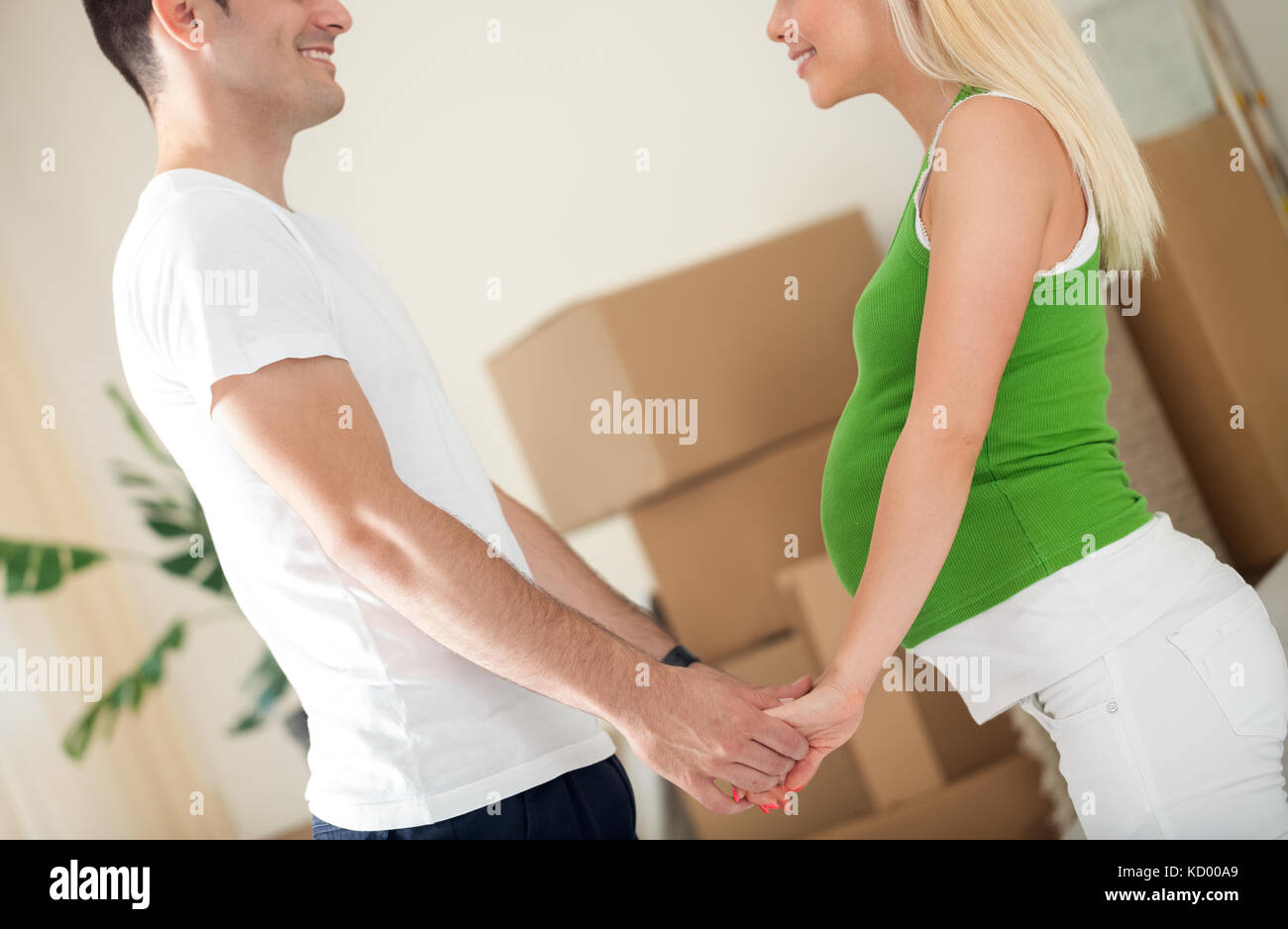 Young future parents in new home with boxes Stock Photo