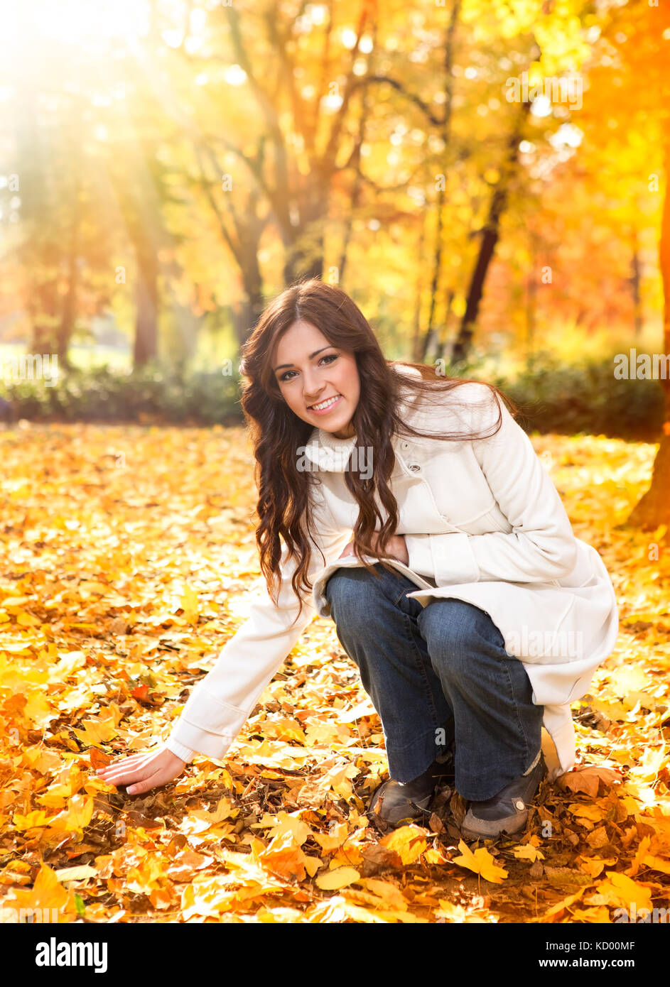 Smiling young woman in autumn park Stock Photo - Alamy
