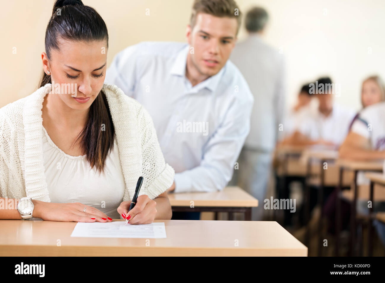 male student trying to cheat at test in class Stock Photo