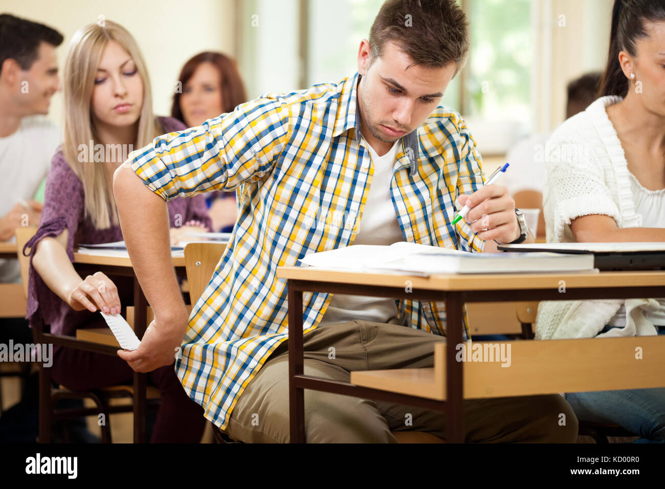 Students during test cheating with cheat sheet Stock Photo