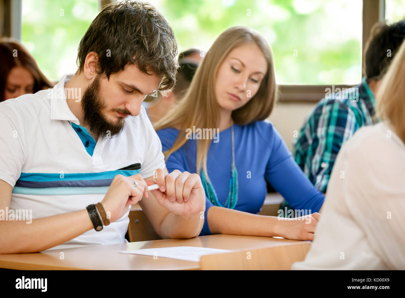 female student transcribed test by her colleague, cheating on test Stock Photo