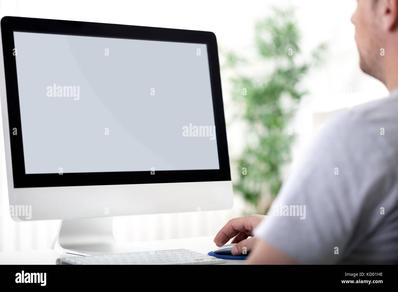 Rear view of a young man working of a computer Stock Photo - Alamy